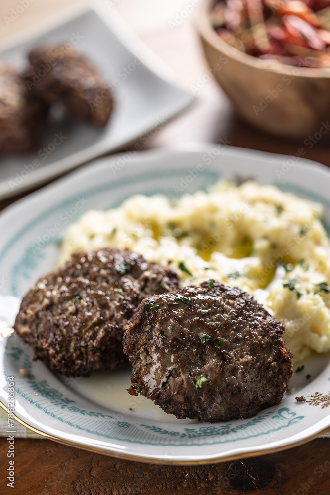 Minced meat cutlets with mashed potatoes topped with clarified butter. Traditional Slovak meatballs - Fasirky with potato puree. Minced meat cutlets with mashed potatoes topped with clarified butter. Traditional Slovak meatballs - Fasirky with potato puree.