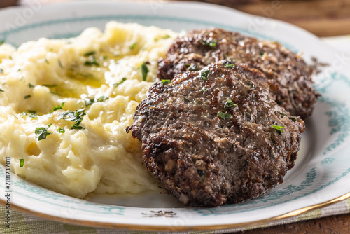 Minced meat cutlets with mashed potatoes topped with clarified butter. Traditional Slovak meatballs - Fasirky with potato puree.
