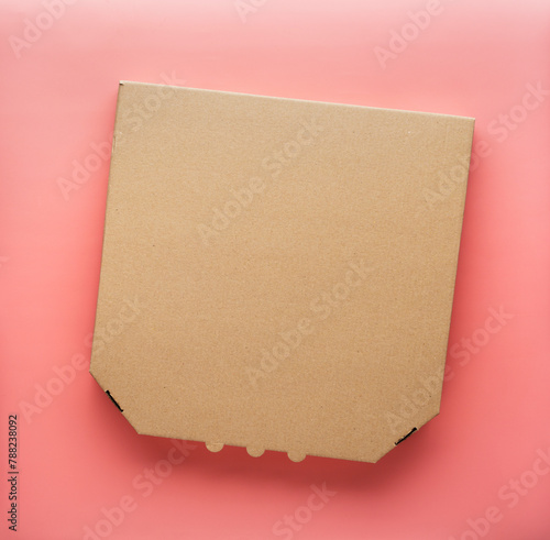 Pizza closed carton box on uniform pink background flat lay mockup with copyspace