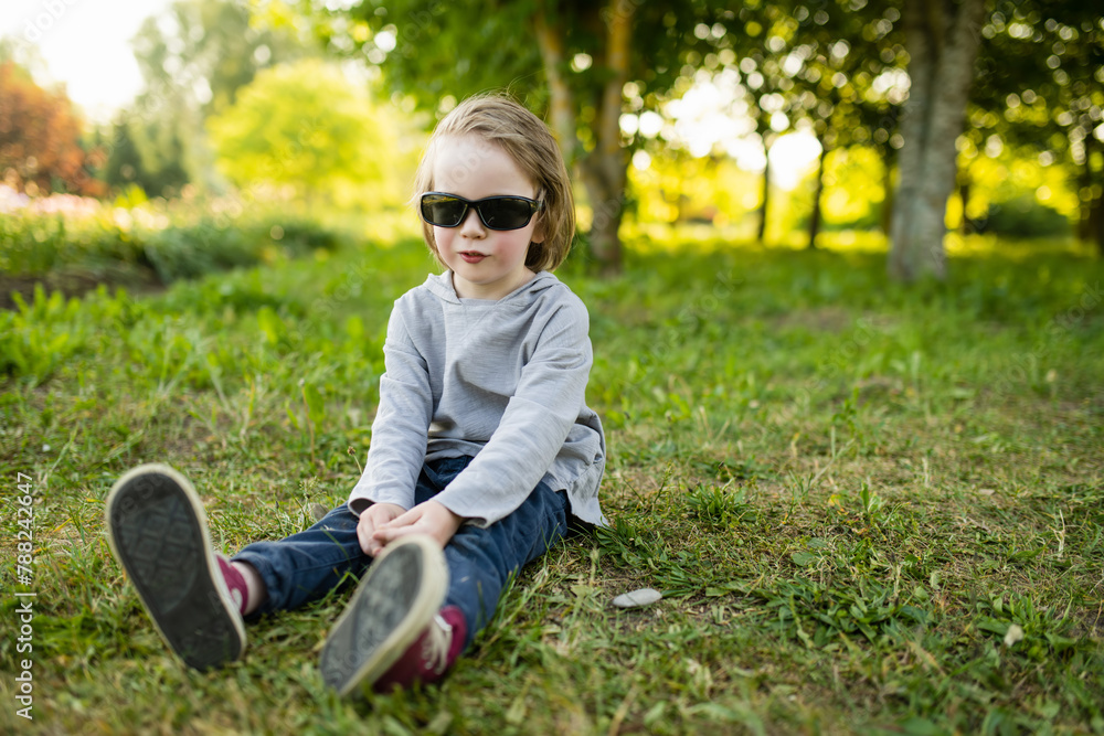 Adorable little boy having fun outdoors on sunny summer day. Kid running outdoors. Child exploring nature. Summer activities for kids.