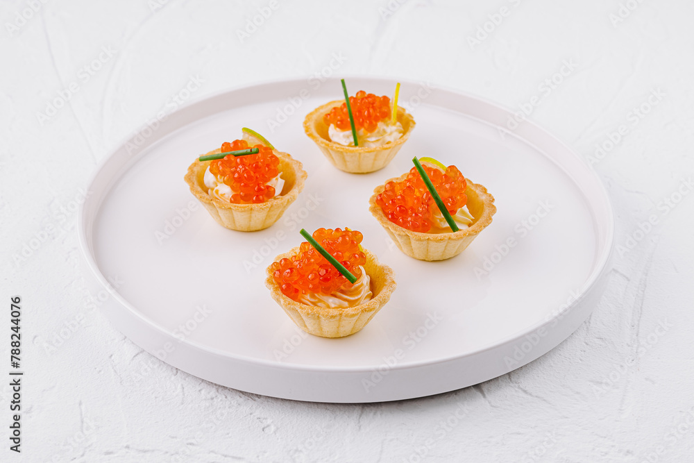 Elegant tartlets with salmon caviar on white plate - obrazy, fototapety, plakaty 