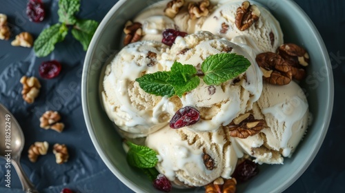 A bowl of white chocolate and walnut ice cream topped with fresh mint leaves. The background is dark blue, which contrasts with the creamy texture of the vanilla milk in the bowl.