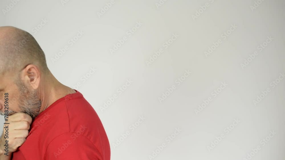Bearded, bald man wearing a red shirt, walks thoughtfully touching his beard. Bearded, bald man wearing a red shirt, walks thoughtfully touching his beard.