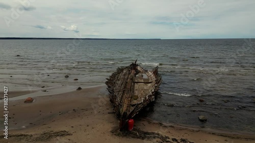 Abandoned shipwreck, An abandoned broken boat full of holes lying on the seashore. Wreck ship on reefs in sea or ocean. The sunken ship, the ship ran aground. Ecological disaster on the Estonian coast (ID: 788271427)