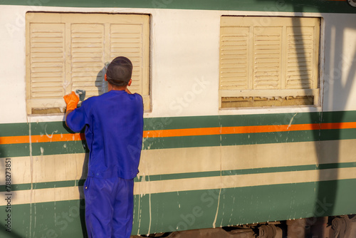 Employees are wiping, washing, inspecting and cleaning trains for use in transporting passengers