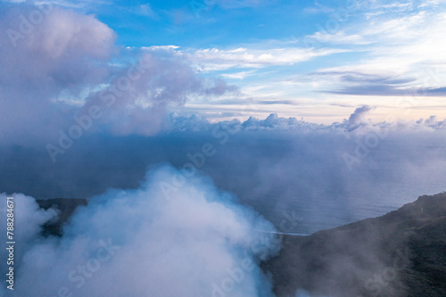 Smoke over volcano crater. Gray clouds ocean background. Vanuatu. Volcano accessible to tourists. © romankrykh