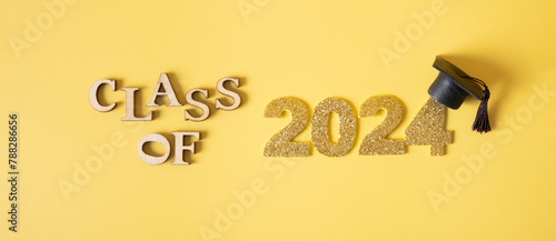 Class of 2024 concept. Number 2024 with graduated cap on yellow background