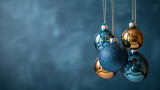 New Year minimalistic background. Golden and blue Glass Balls hanging on ribbon on a Navy blue background.