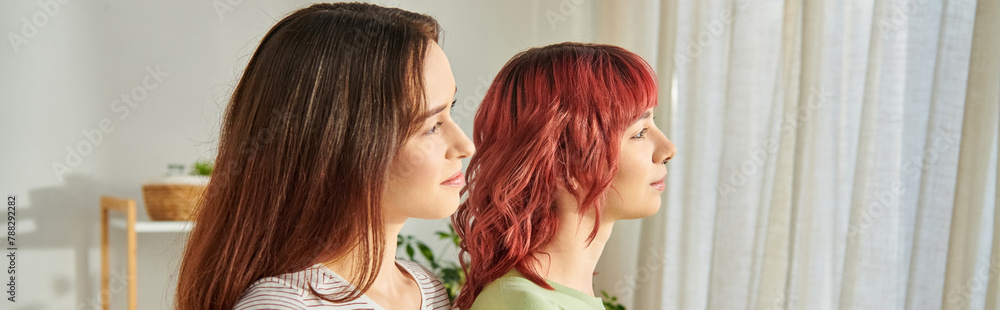 banner of young lesbian couple embracing while looking away, their faces full of bliss and love banner of young lesbian couple embracing while looking away, their faces full of bliss and love