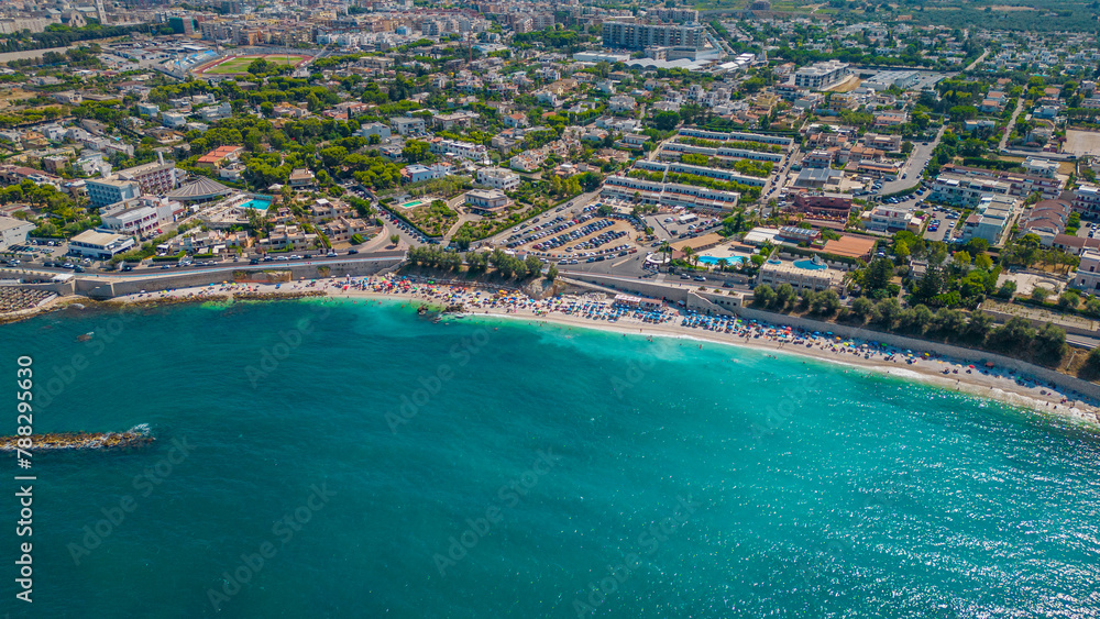 Fototapeta premium Top view, splendid aerial view of some people relaxing on a beautiful beach washed by the sea. Bisceglie (Apulia, Italy)