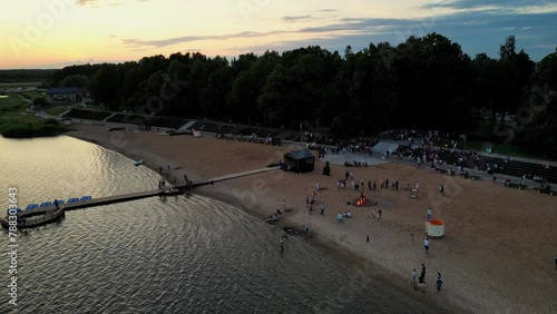 Birds eye view of friends at beach party roasting marshmallows above bonfire. Bonfire bright sparks coals orange warm light burning log. Celebrating the Midsummer day. (ID: 788303643)