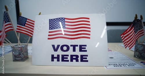 National Election Day in the United States of America. Sign with American flag logo standing on the table, calling for voting in polling station office. Political races of US presidential candidates. photo