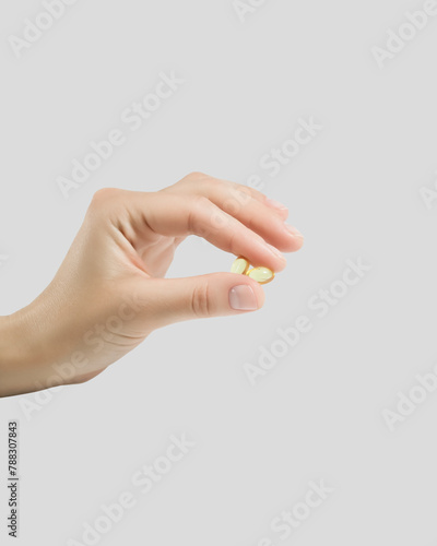 hand holding two vitamin capsules. taking vitamins and nutritional supplements for female beauty and health