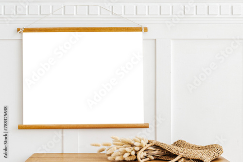 Poster hanger mockup over a wooden sideboard table with hare's tail grass in a wicker bag photo