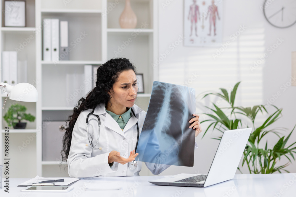 A professional female doctor examines an X-ray film, focusing intently in her modern office filled with medical charts and plants. A professional female doctor examines an X-ray film, focusing intently in her modern office filled with medical charts and plants.
