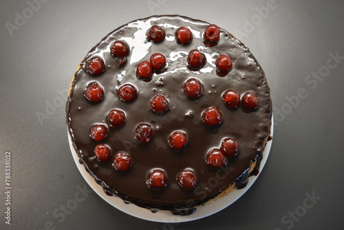 Food, Finnish cuisine, desserts. A very tasty sponge cake made with buttercream, chocolate frosting and red cherries.