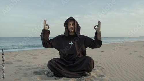 Monk Does Breathing Meditation Sitting On The Beach At Sunset