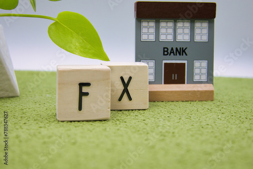 緑の絨毯に置かれたFXの文字ブロック