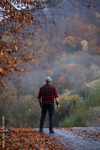 Handsome Strong Young Man in Plaid Shirt in Autumn Forest