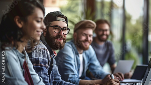 Men and women sitting working and smiling together in office