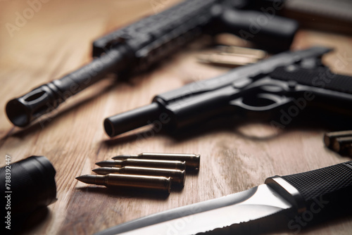 Weapons and military equipment for army, Assault rifle gun, handgun and knife on wooden background. © luengo_ua