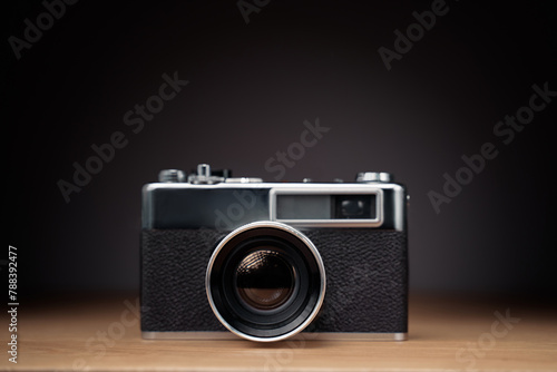 Vintage film camera on wooden table. © luengo_ua