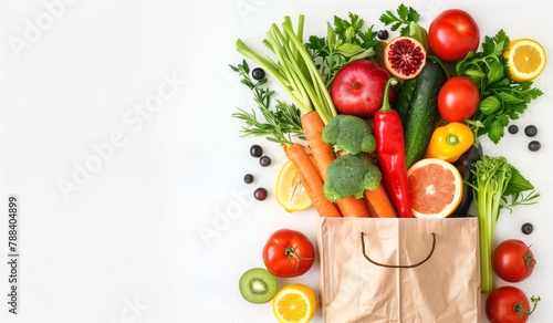 A variety of colorful fresh vegetables and fruits, such as carrots, broccoli, tomatoes, and apples, are arranged to seem as if they are tumbling out of a brown paper bag, with a clean white BG.
