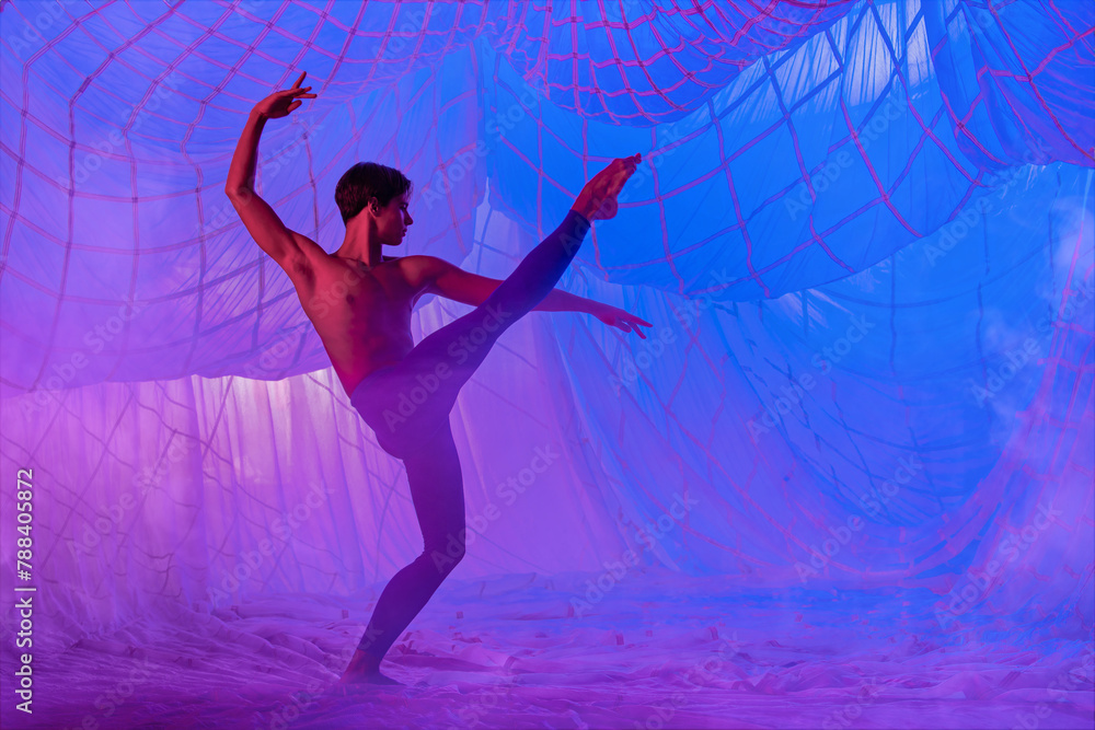 A man in a blue suit dances ballet on a blue background. A man in a blue suit dances ballet on a blue background.
