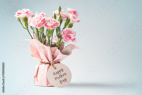 Pink flower bouquet with mothers day card on vintage blue background