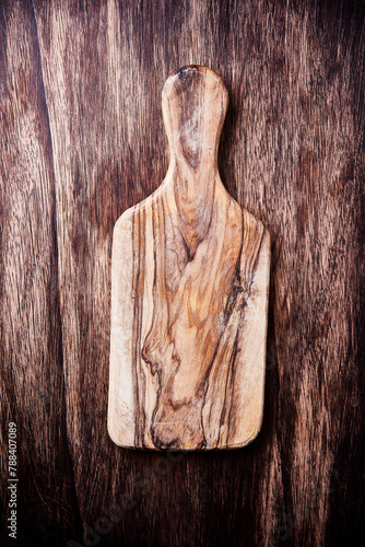 Cutting board on rustic wooden background. Top view. Close up. Copy space.
