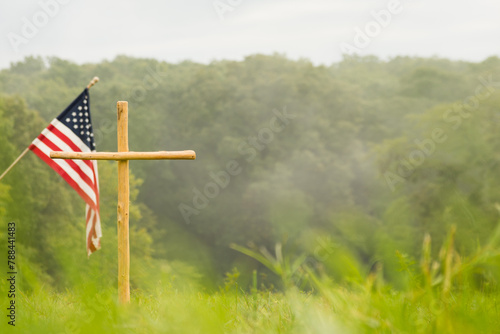 a cross and american flag in a field