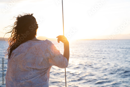 Rear View of a Young Woman Watching the sunset in a Sealandscape Against the Horizon.Copy Space
