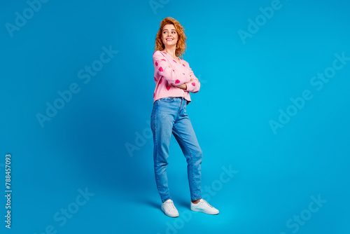 Full length photo of lovely young lady crossed hands look empty space dressed stylish pink clothes isolated on blue color background