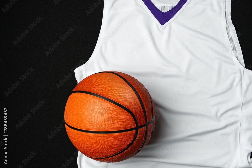 Close-Up of Basketball and White and Purple Jersey on a Black Background Close-Up of Basketball and White and Purple Jersey on a Black Background