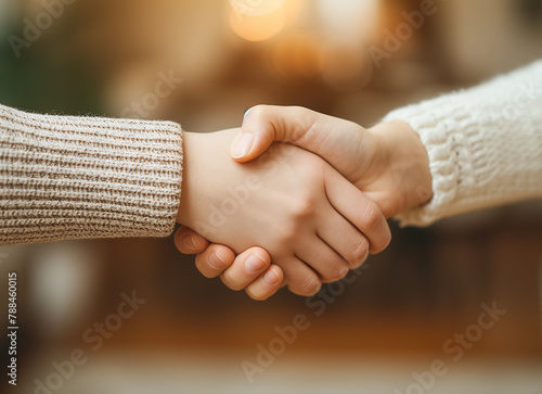 Young man and woman with bare arms shaking hands clasping each other tightly, closeup view of the handshake