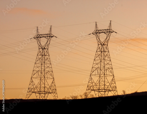 Three power towers against a blue sky