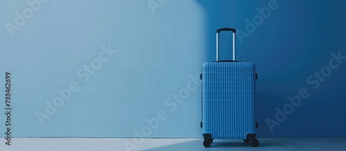 Minimal travel concept with a blue suitcase against a soft blue background.