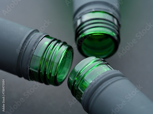 A close-up shot of three open neck of wine bottles on a black background
