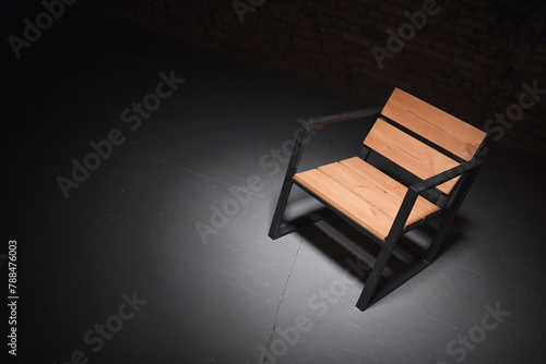 Iron loft style armchair on the black dark background. Front view. photo