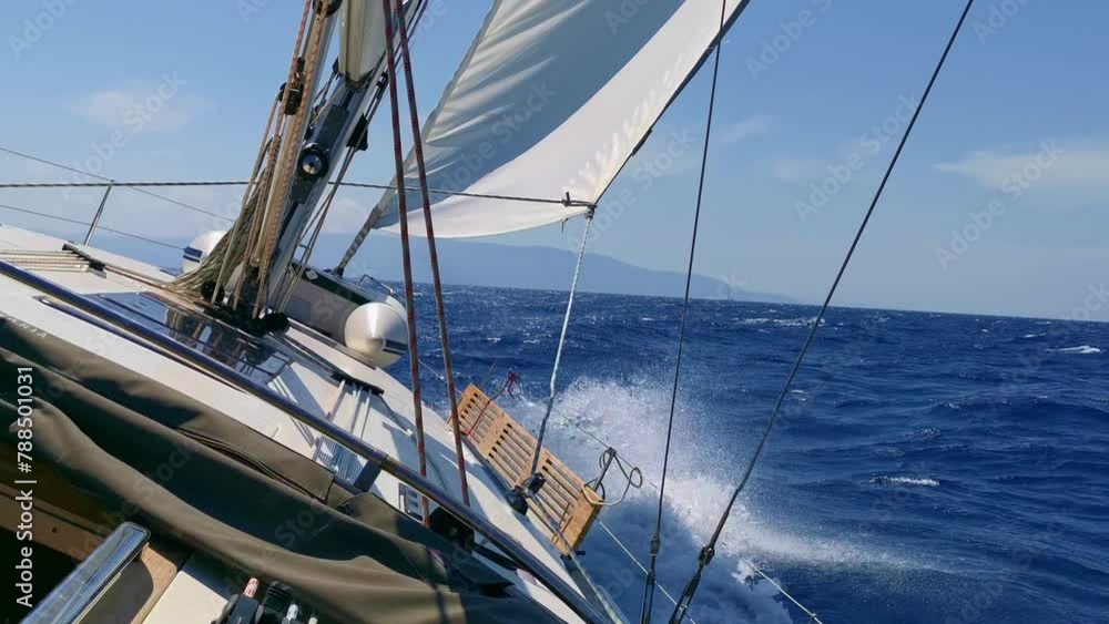 Yacht Under Sails racing across the sea on a sunny summer day. Vacation and Sailing