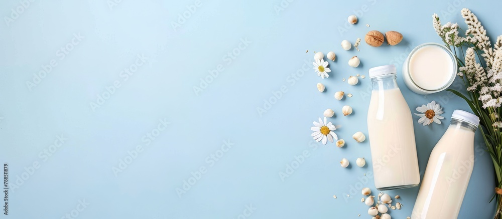Ingredients for creating different plant-based dairy-free vegan milks and milk bottles on a blue background with space for text.