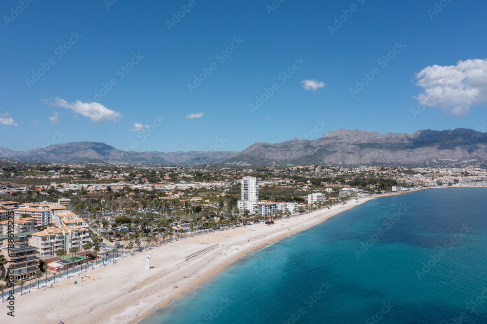 Aerial drone photo of the Spanish town of L'Albir in Spain Alicante showing the beach front on a sunny summers day with the Spanish mountains in the background