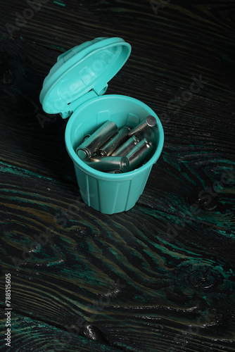 Used finger batteries in a miniature trash can.