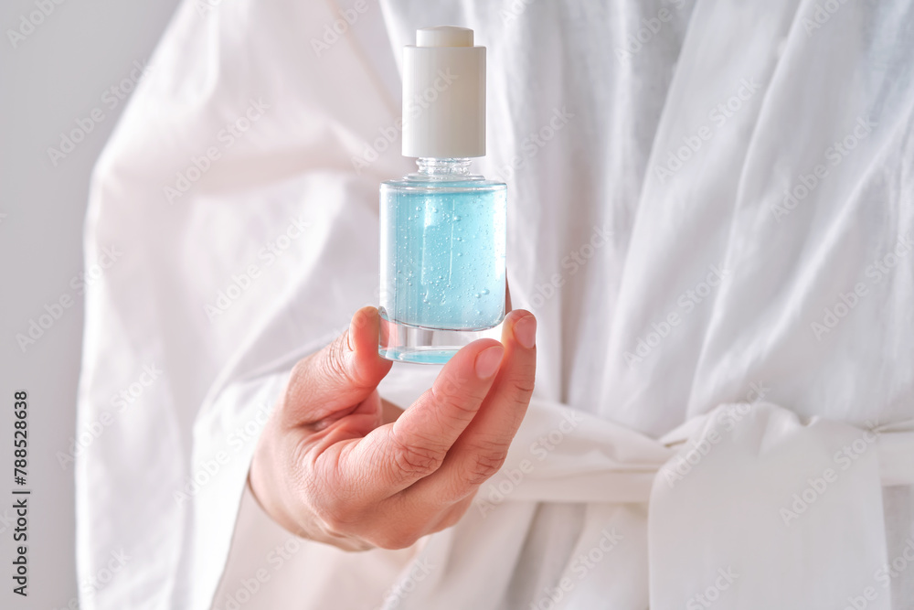 Blue serum with pipette in a womans hands in a robe. Blue serum with pipette in a womans hands in a robe.