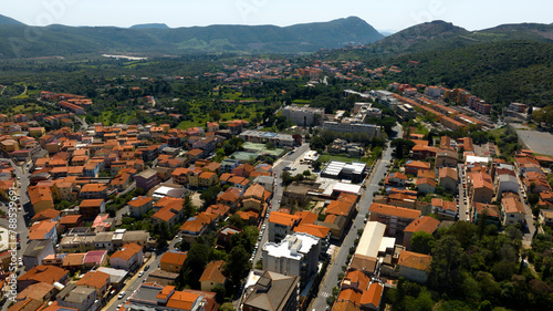 Aerial view of outskirts of Iglesias, an Italian municipality. It is located in southwestern Sardinia, Italy, in the Iglesiente region. All the houses have characteristic red roofs.
