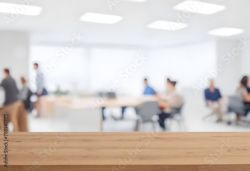 Multiple people in an office environment with a wooden table in the foreground