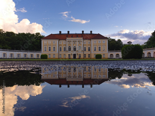 Pałac w Pawłowicach na tle błękitnego nieba wraz z odbiciem w kałuży © Bartosz