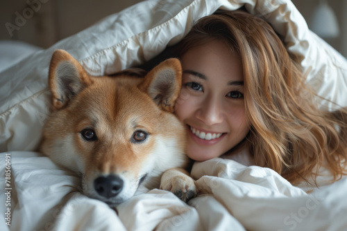 Cheerful Woman Cuddling with Shiba Inu Dog Under Cozy Blanket © smth.design