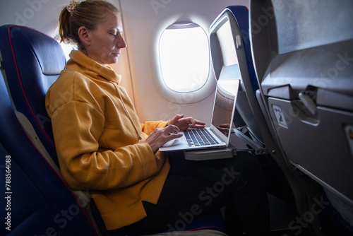 woman working on a laptop during flight