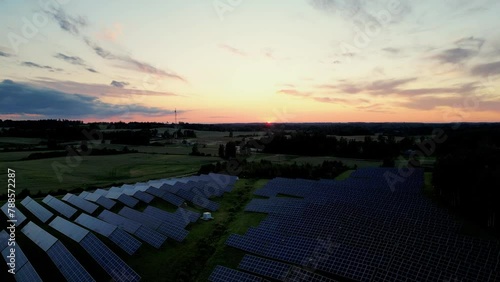 Drone footage of a solar power plant at sunset solar farm with photovoltaic panels converting solar power to electricity for green energy, Solar panels in Estonia sunset background in summer time (ID: 788572287)